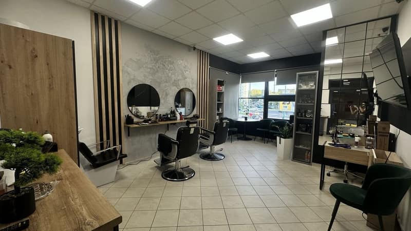 Panoramiczny widok wnętrza ALIA Barber Tychy ze stanowiskami i strefą dla klientów